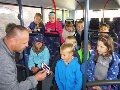 Trainer zeigt Kindern ein Piktogramm bei der BusSchule.